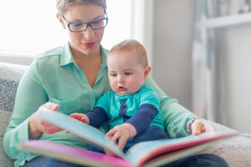 Cute baby reading with his mother