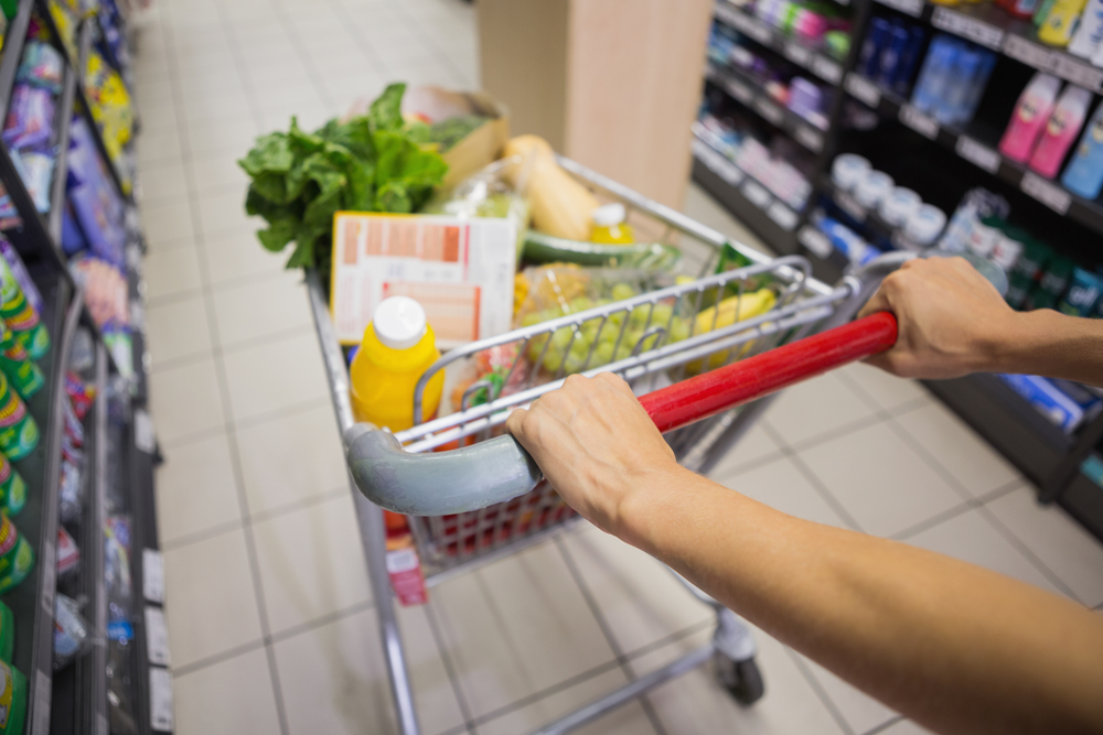 woman buy products with her trolley at supermarket